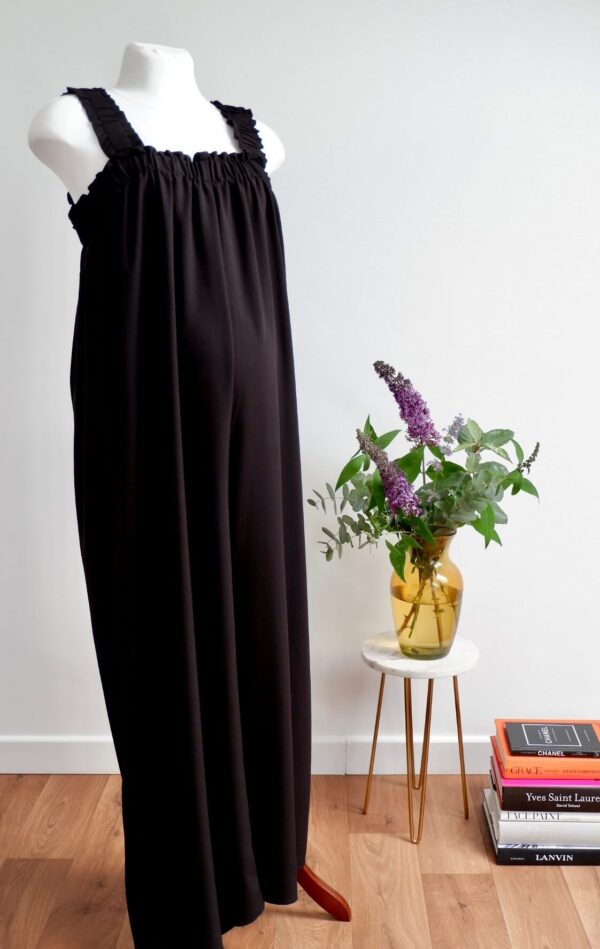 Image of black maternity jumpsuit with square neckline and elastic shoulder straps