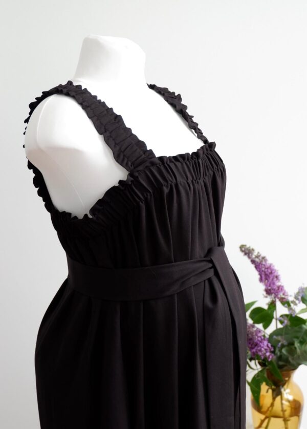 Image of black maternity jumpsuit from waist up with square neckline, thin straps and waist belt