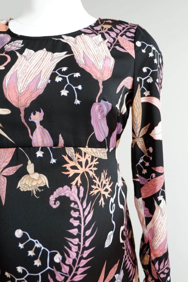 Front image of H&M maternity pink and black floral patterned dress showing over the bump seam.