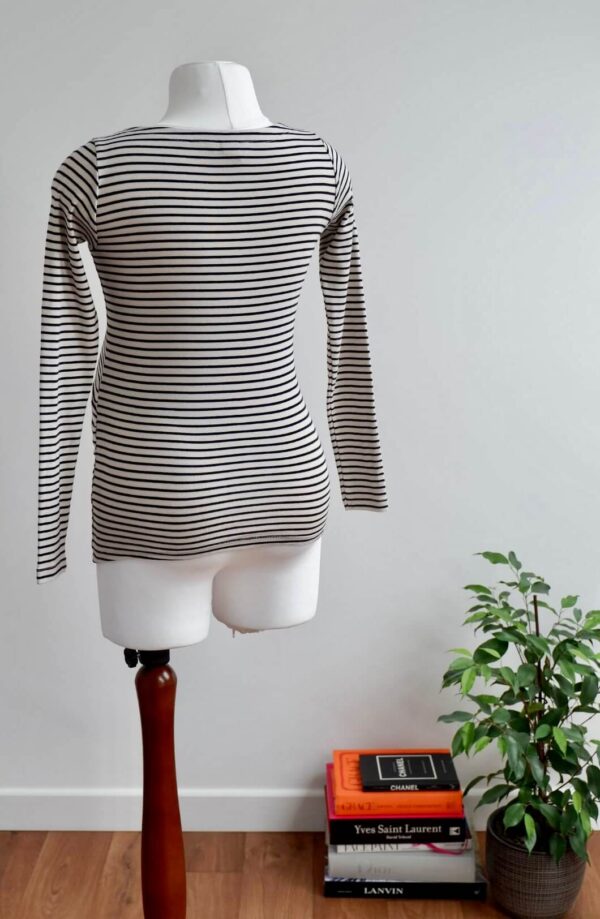 Back image of H&M maternity black and cream striped long sleeve top on a mannequin against a while wall background