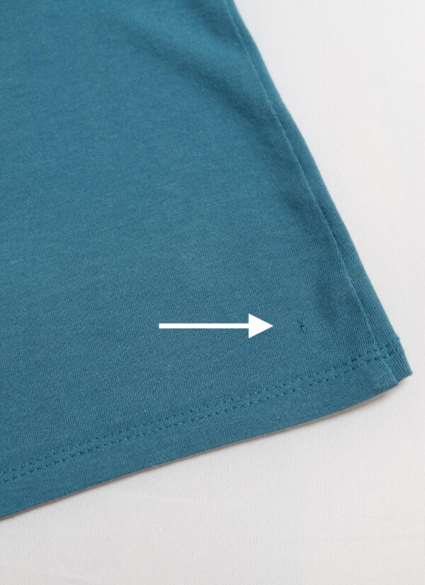 Image of section of H&M Teal nursing vest with a white arrow pointing to a small whole