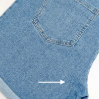 Flat lay image of folded Kmart maternity shorts showing small repair near the crotch.