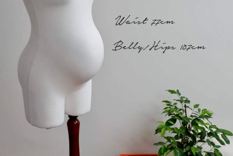 Imagine of pregnant mannequin with text to the right showing the measurements of the bust, waist and belly and hips.