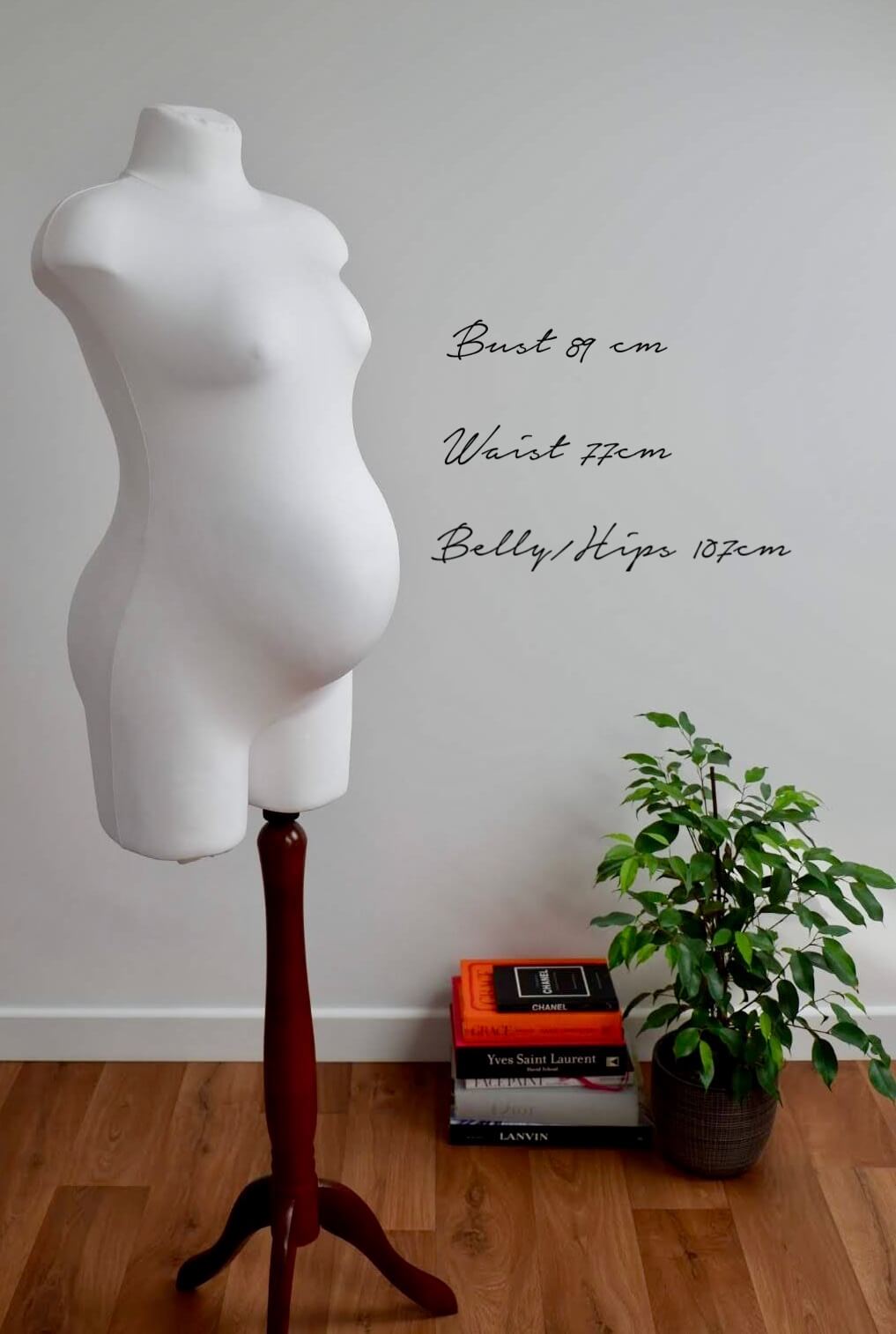 Imagine of pregnant mannequin with text to the right showing the measurements of the bust, waist and belly and hips.