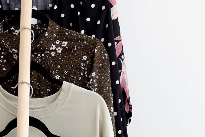 Image of preloved maternity clothes hanging vertically again a white wall