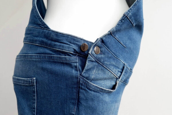 Close up image of side adjustable waist buttons on Seraphine maternity dungarees.