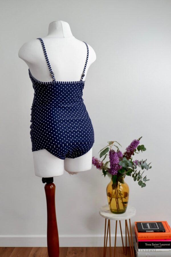 Back of blue and white polka dot maternity swim vest on a mannequin